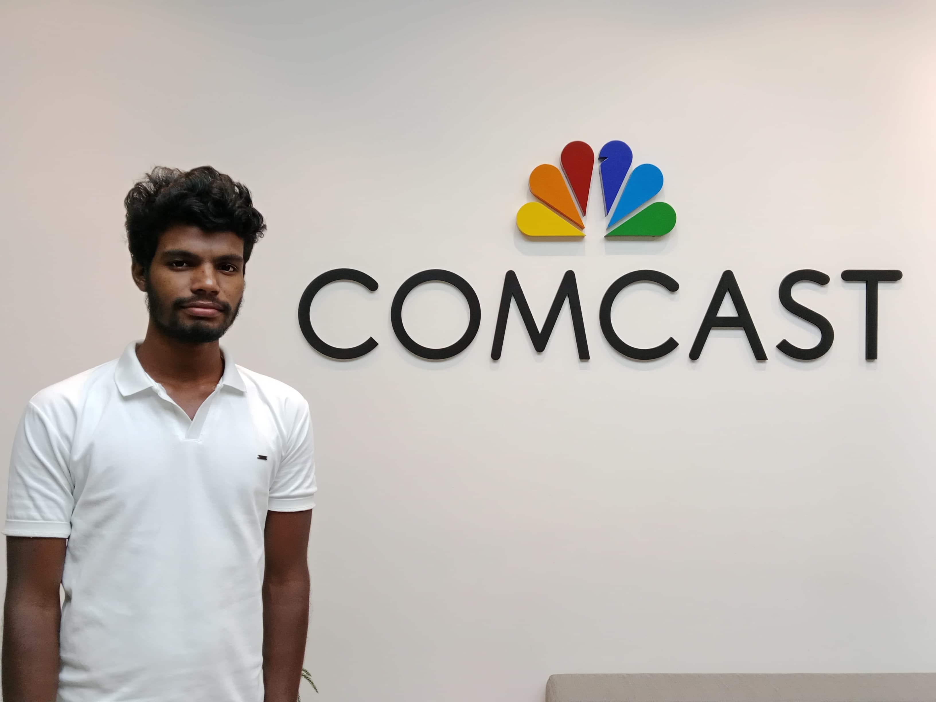 Picture of Hemath in-front of Comcast logo