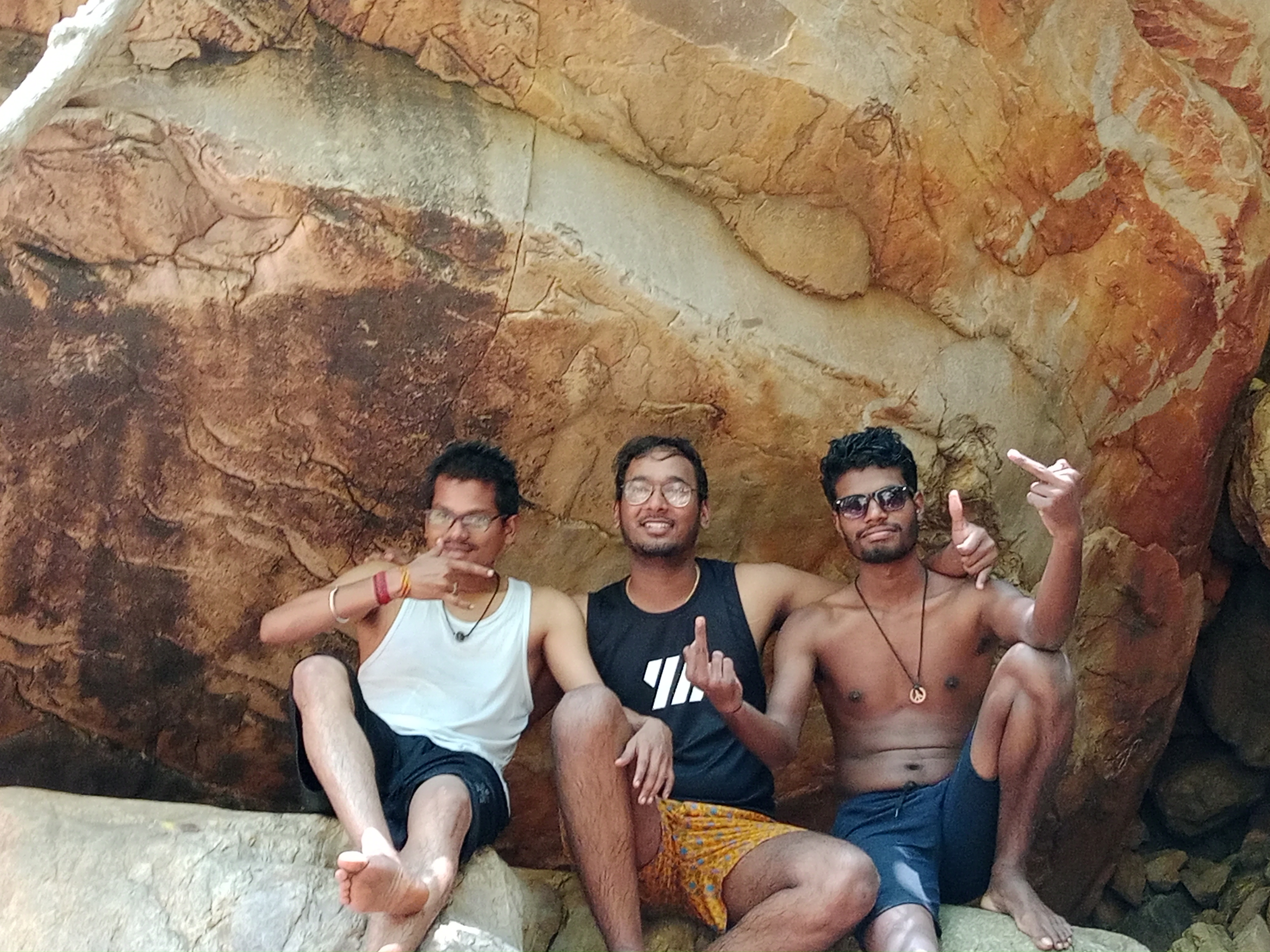 Hemath, Pavan and Prakash posing near a rock